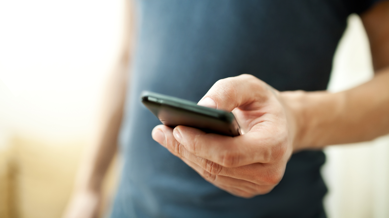 A man holding a smartphone on hand; image used for HSBC Safeguard. 