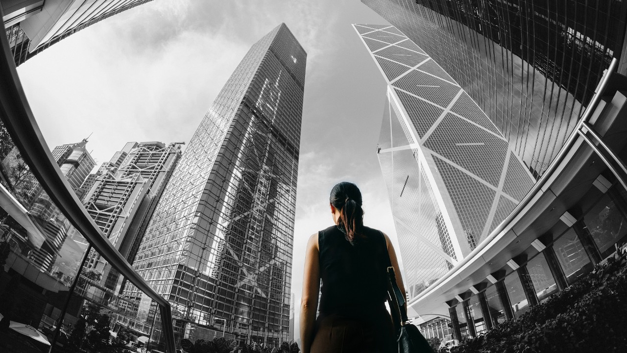 A woman standing in financial skycrapers; image used for HSBC Australia Exchange Traded Funds (ETFs).