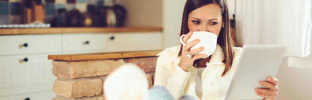 A woman drinking coffee and viewing iPad; image used for HSBC Australia eStatements.