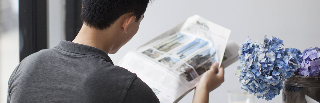 A man reading newspaper; image used for HSBC query transaction.