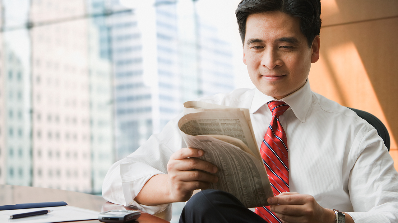A man is looking the newspaper; image used for HSBC Market News.
