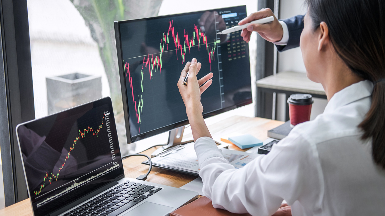 Two people analyzing stock trends with laptop; image used for HSBC Australia investment research and insights.