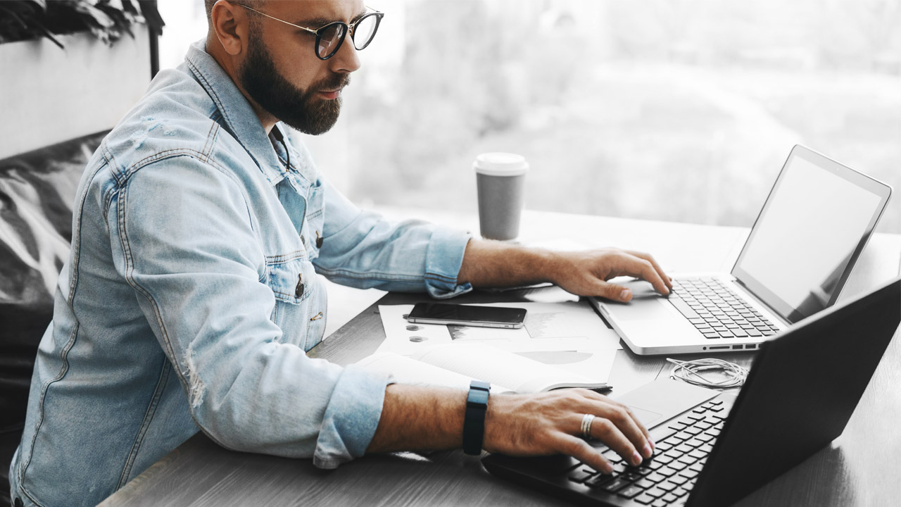 A businessman using computer in empty office; image used for HSBC Financial Health Check.