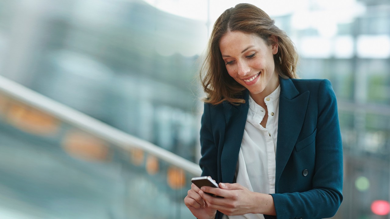 A young business woman using smartphone outdoor; image used for HSBC What is a joint account.