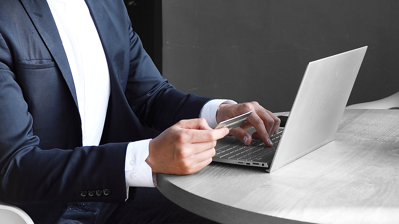 A person looking at a credit card while checking on laptop; image used for HSBC Australia activate your credit card.