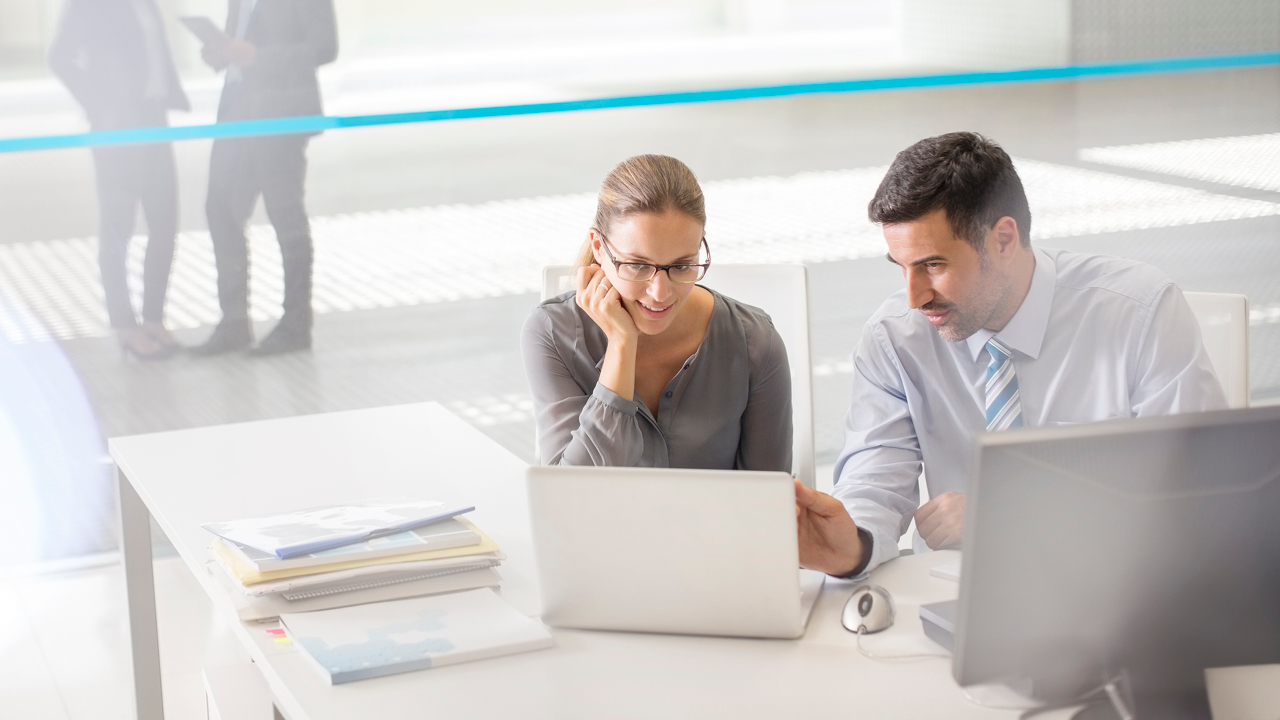 Team sitting on office and discussing with laptop; image used for HSBC Australia managed funds.