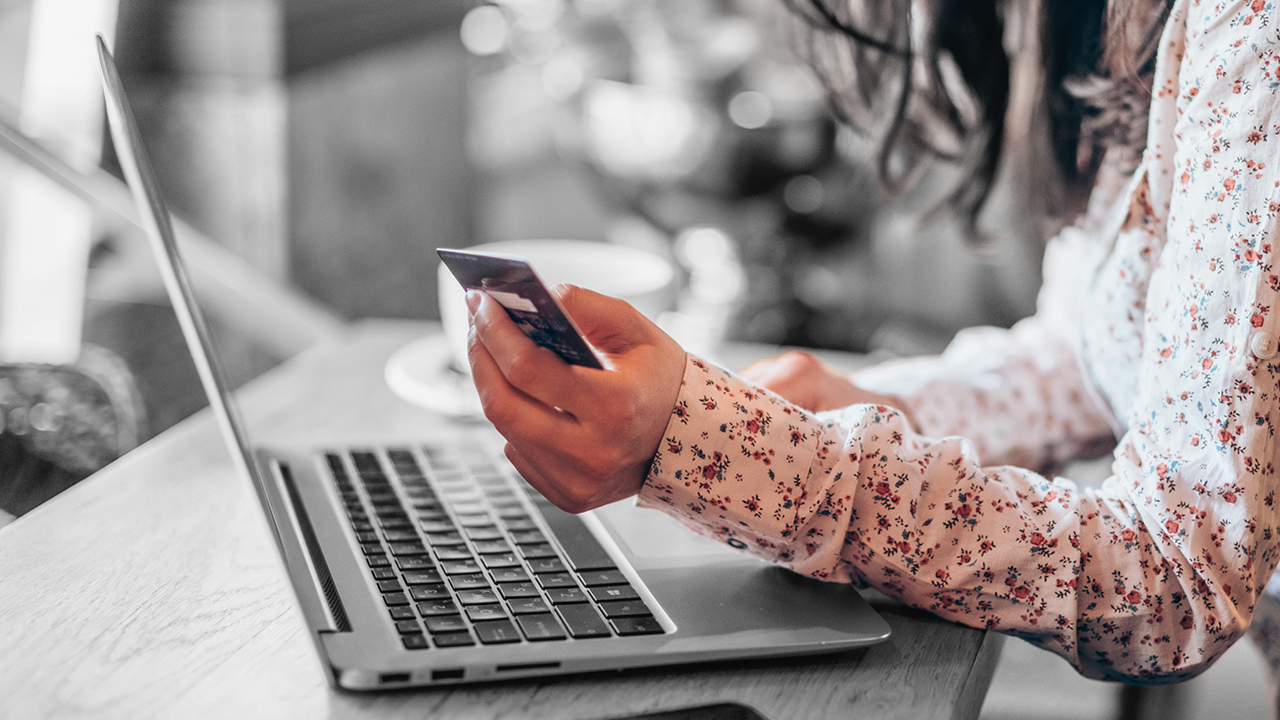 A person looking at a credit card while checking on laptop; image used for HSBC Australia activate your credit card.