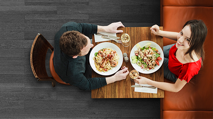 Girl looks up and smiles when having dining with her friend; image used for HSBC Transaction Accounts Comparison.