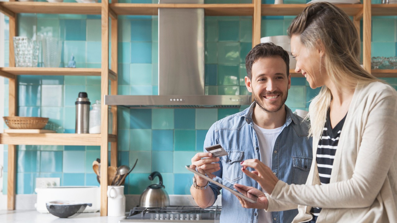 A couple using tablet and card in kitchen; image used for HSBC Australia Interest Free.