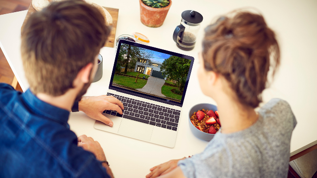 Couple reading new house plan on laptop; image used for HSBC Property Expert.