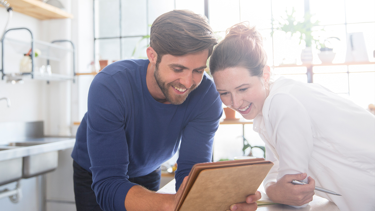 Couple reading on iPad in kitchen; image used for HSBC Australia frequently asked questions page