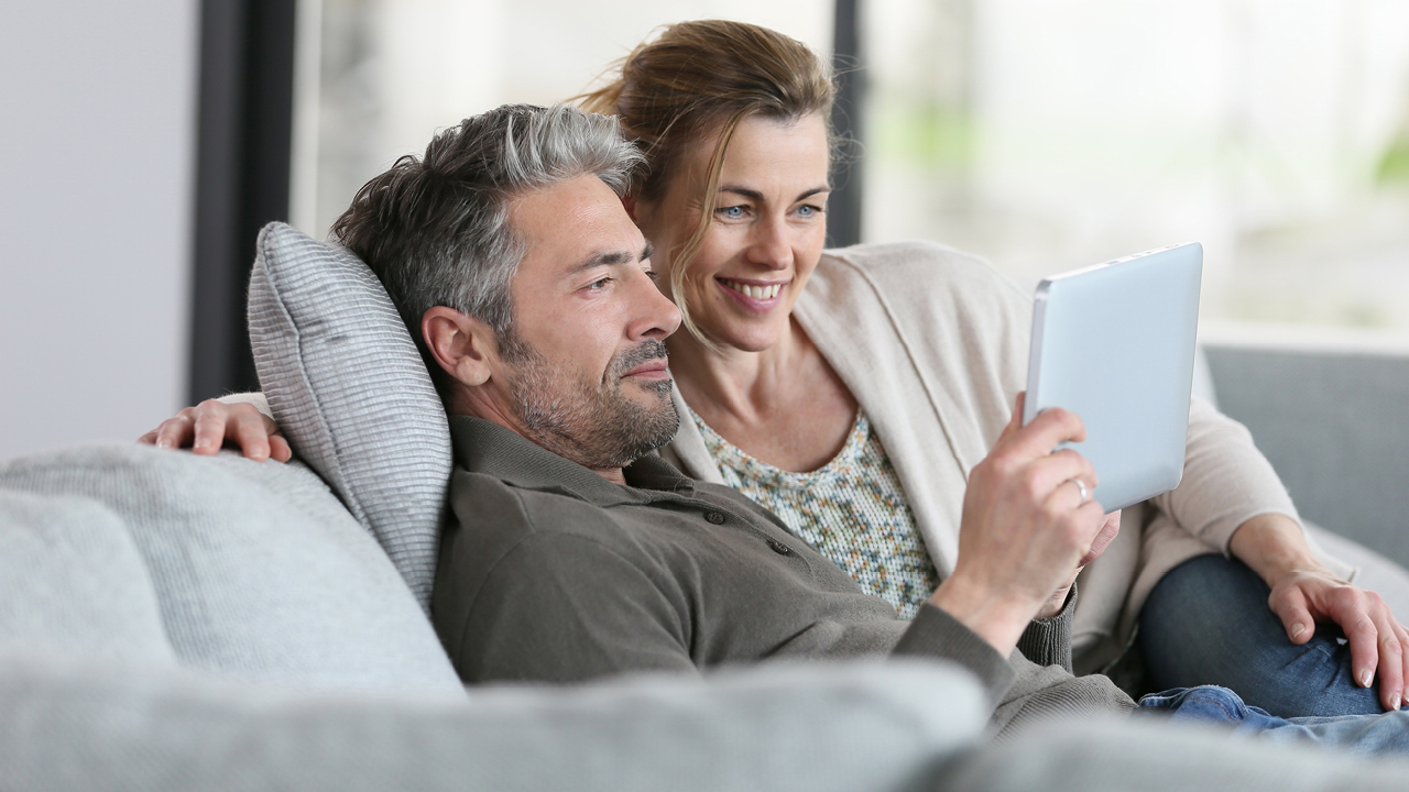 Couple using a tablet in sofa; image used for HSBC Australia retrieve your general insurance quote