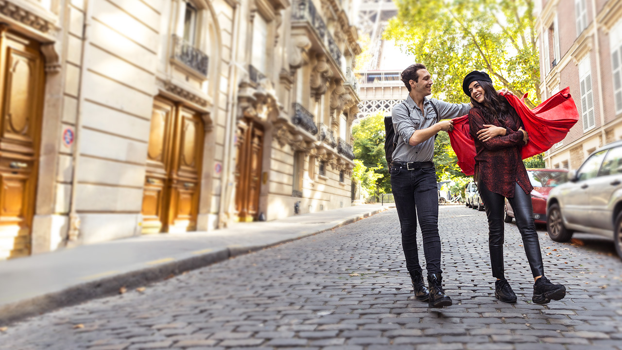 A man is helping a lady to wear the cape; image used for HSBC Australia Platinum Qantas Credit Card page.