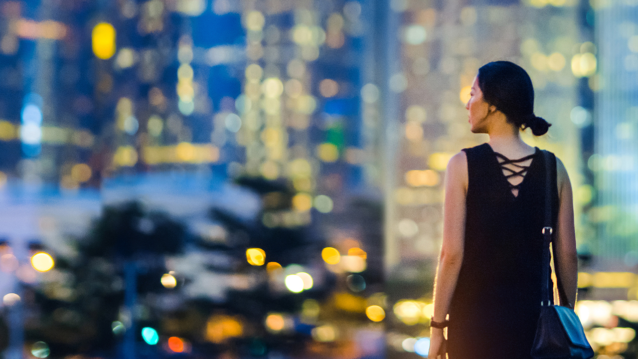 A girl looking left in front of buildings; image used for HSBC Foreign Exchange.