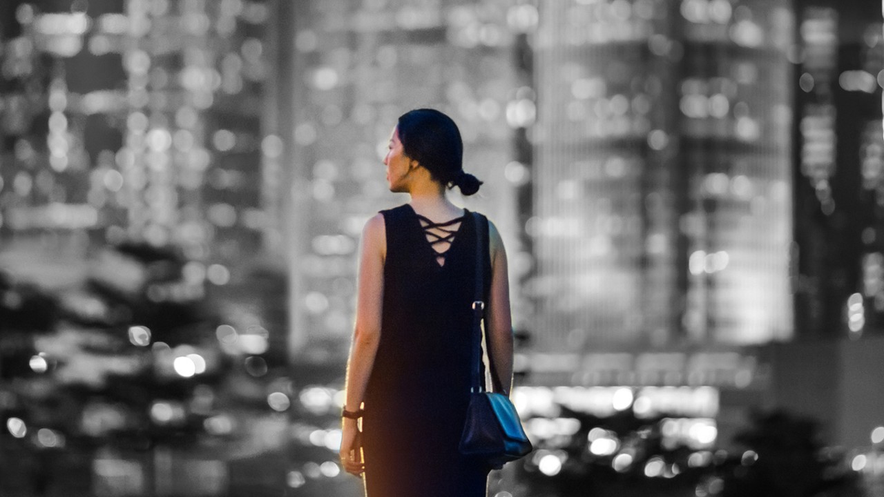 A woman looking left in front of buildings; image used for HSBC Australia Foreign Exchange.