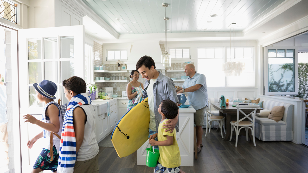 Happy family ready to go with surfboard from their home; image used for HSBC offers page.