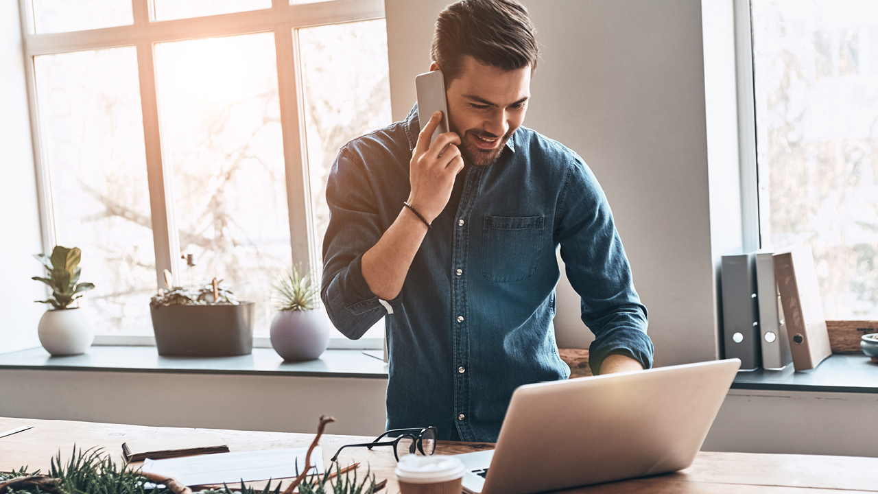 A man is talking on phone while typing on his laptop; image used for HSBC Australia what is a balance transfer