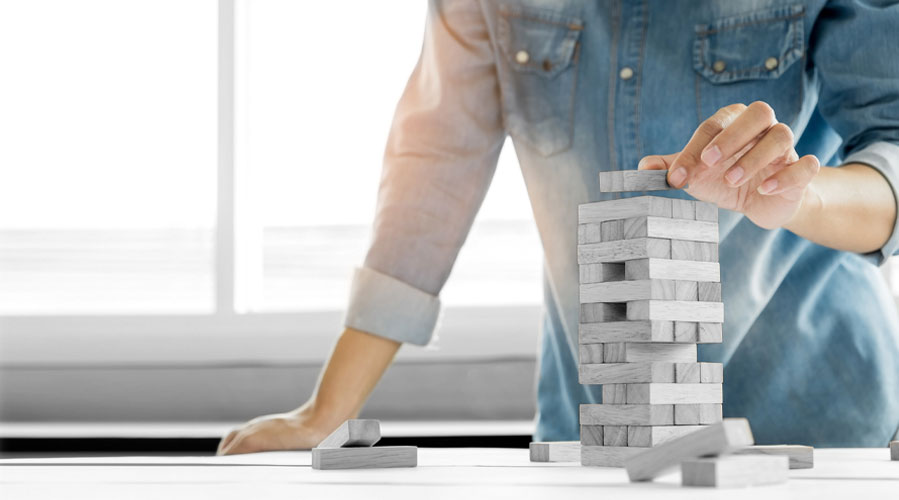 A man playing Jenga game on a table; image used for HSBC Australia Serious Saver Account page.