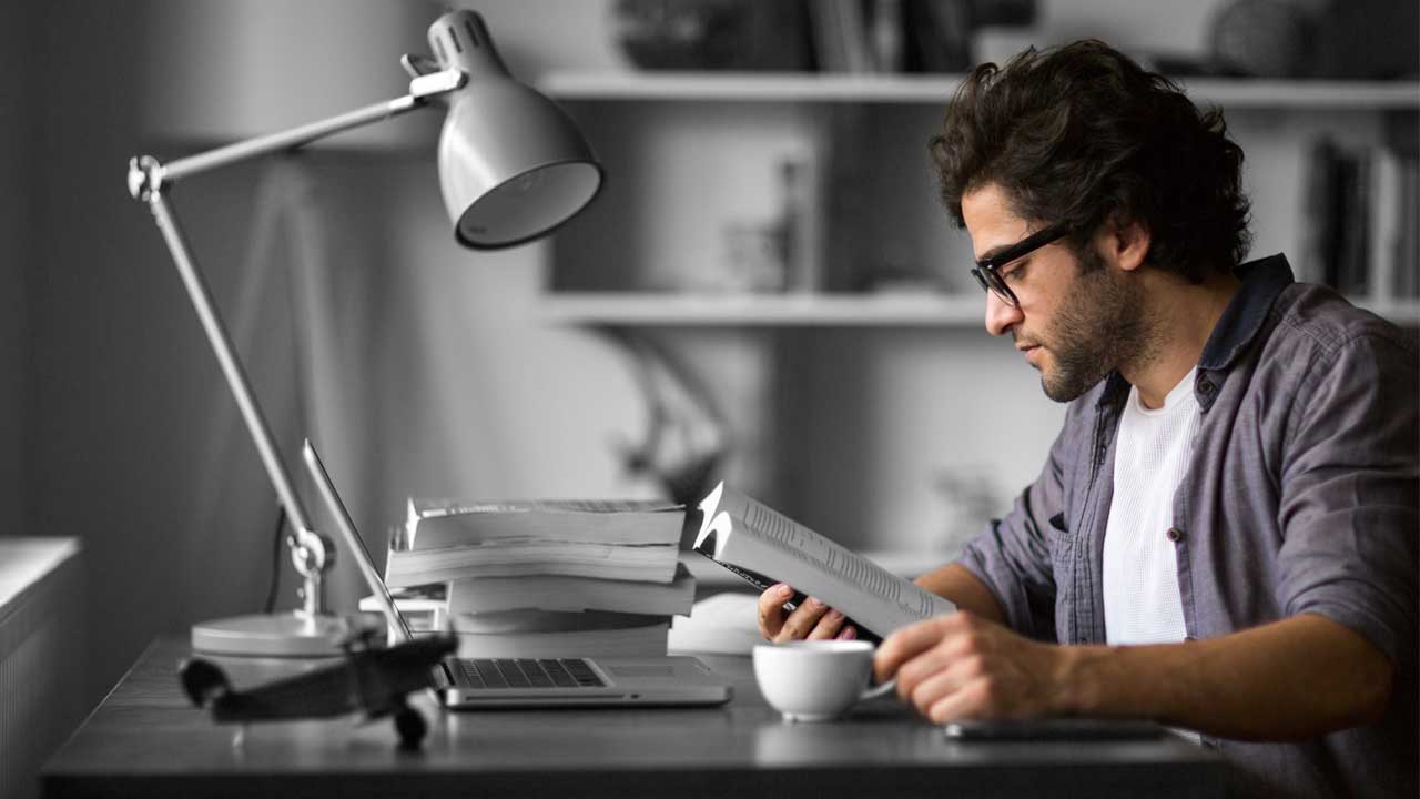 A man reading book on a desk; image used for HSBC Australia Education Loan.