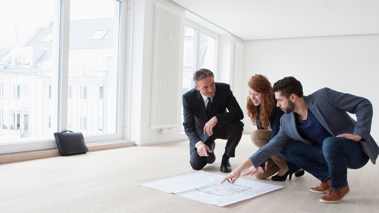 Young couple viewing flat with estate agent; image used for HSBC tips for auctions page.