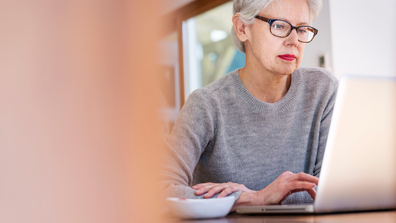 A mature woman viewing on her personal laptop; image used for HSBC Fraud page.