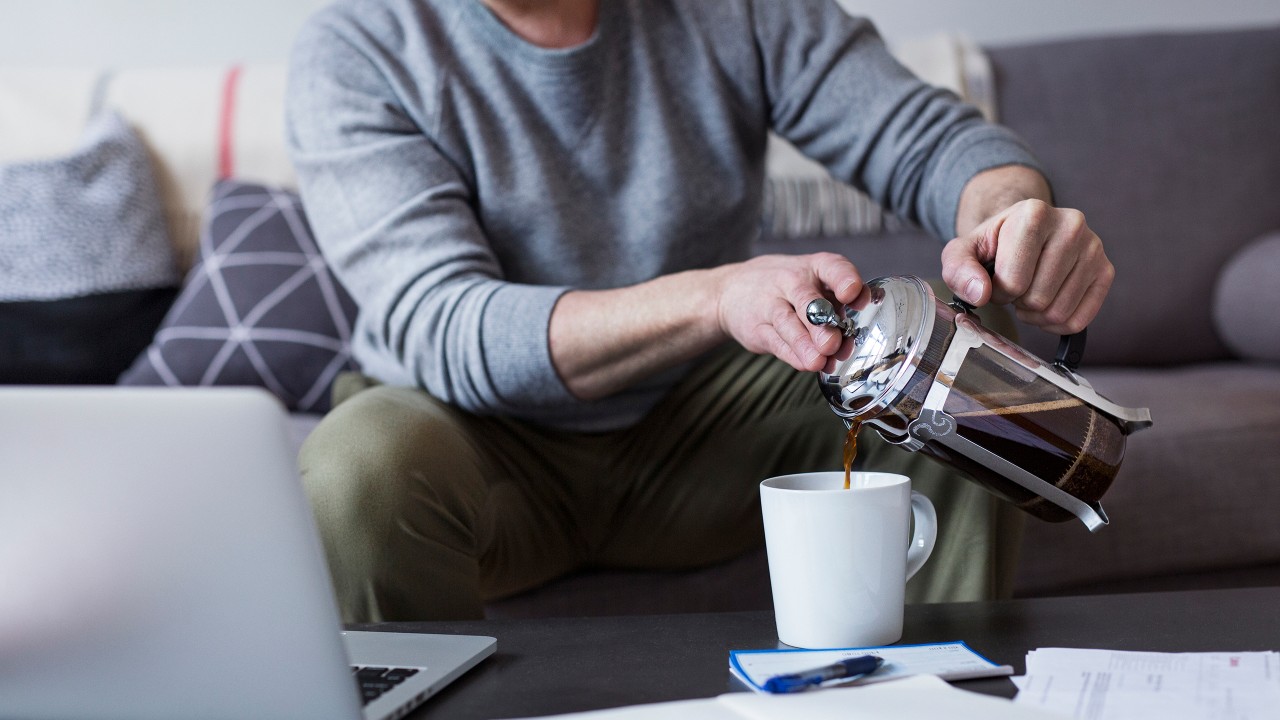 A man pouring coffee at home; image used for HSBC investing in property page.