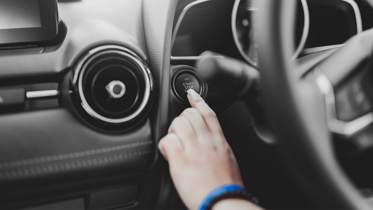 Pushing an engine start button of a car; image used for HSBC Australia car loan page. 