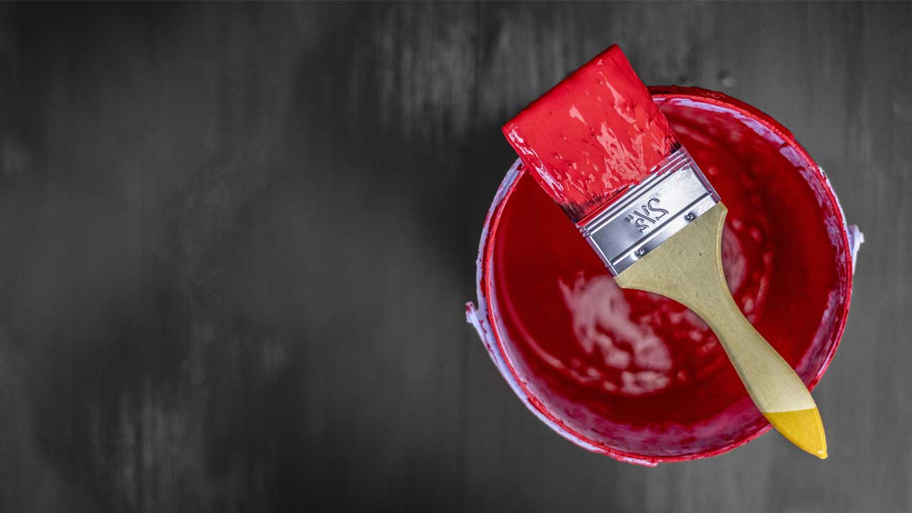 A red paint color tin can and a brush on the floor; image used for HSBC Australia renovation loan page