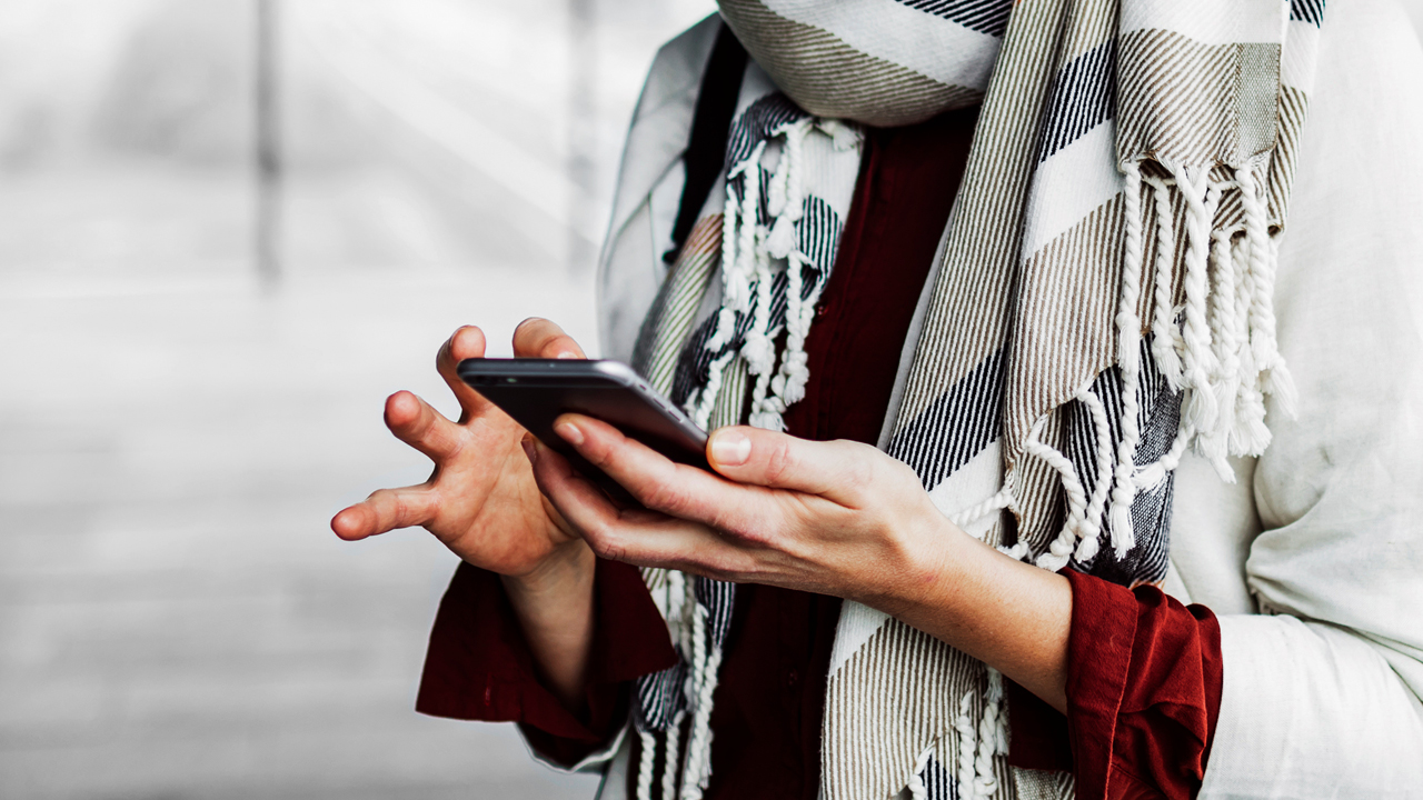 A person typing on the mobile phone; image used for HSBC Australia report a lost and stolen card.