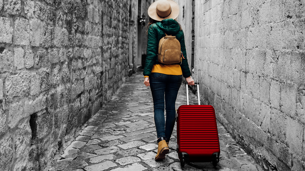 A woman carrying her luggage on a street; image used for HSBC Australia