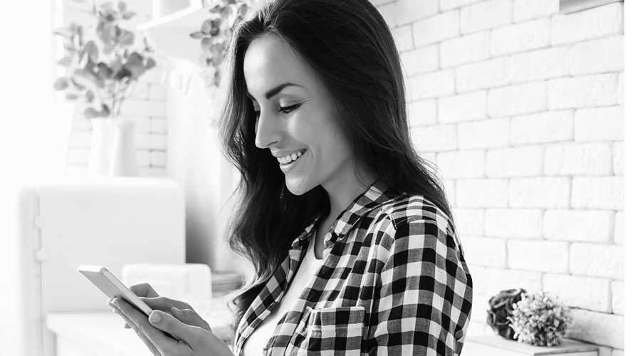 A woman checking mobile in a living room; image used for HSBC Australia getting on top of your finances.