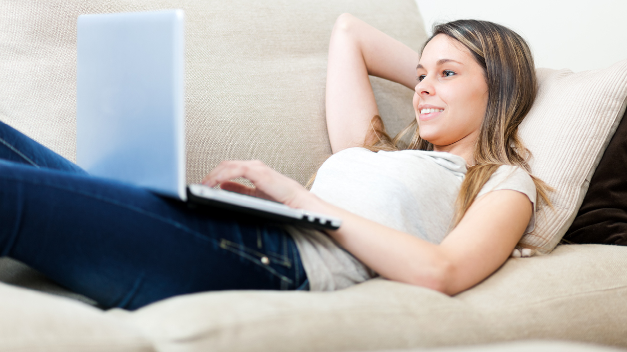 A woman using laptop on sofa; image used for HSBC Australia Compare accounts 