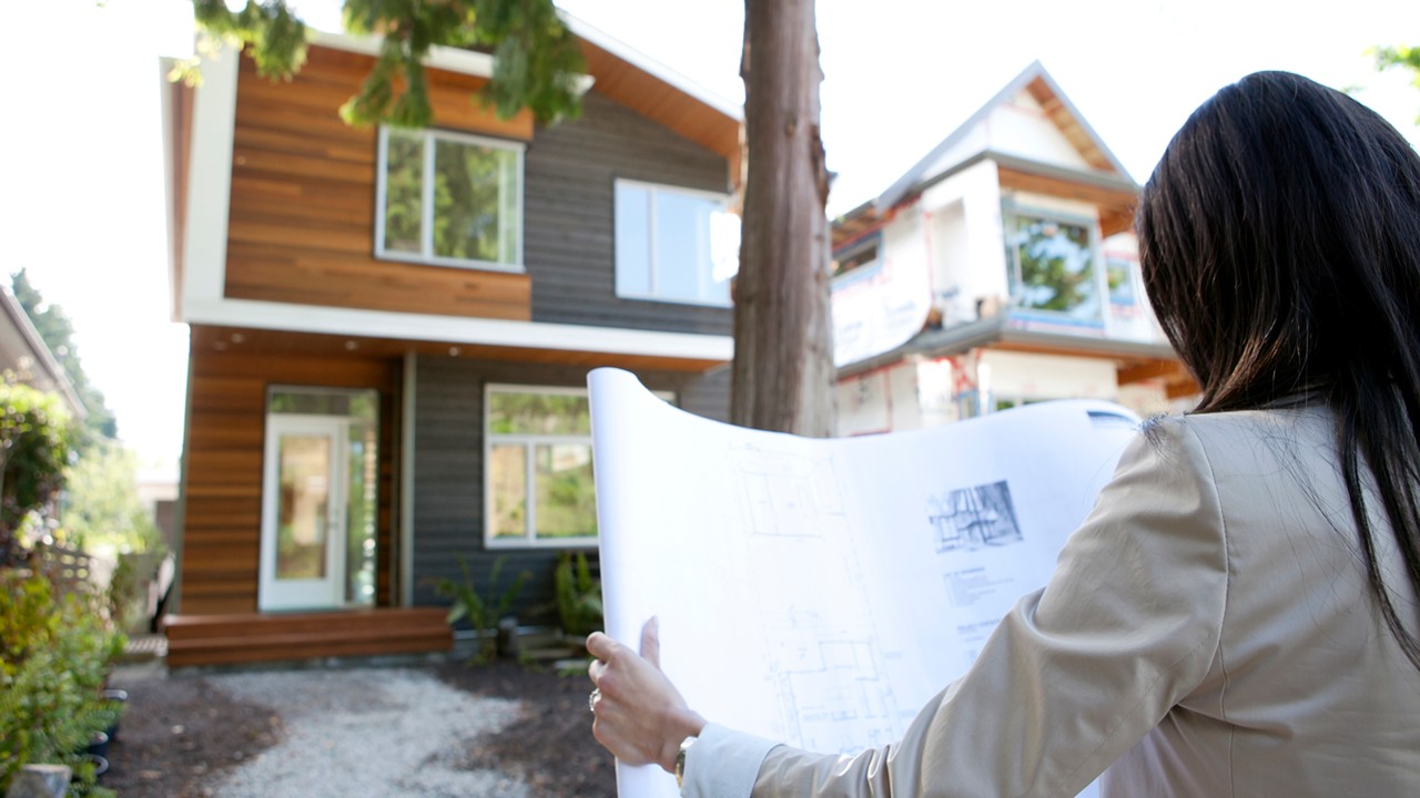 A woman looking at plans; image used for HSBC guide to buying a property page.