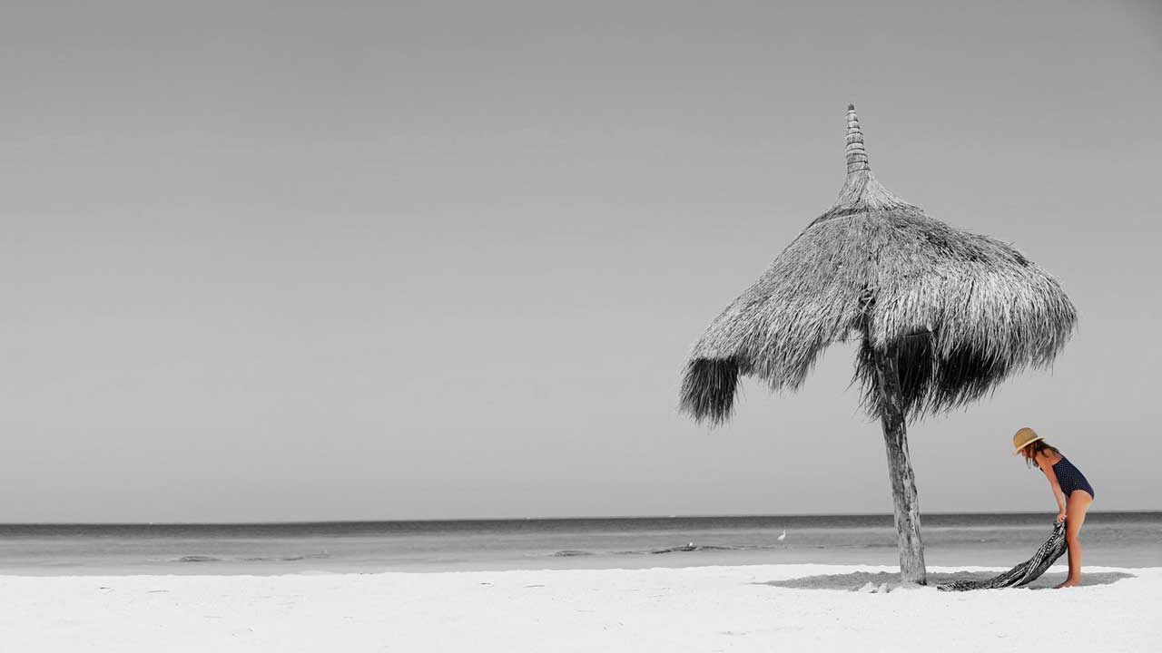 A woman putting a mat on beach side; image used for HSBC Australia holiday loan page.