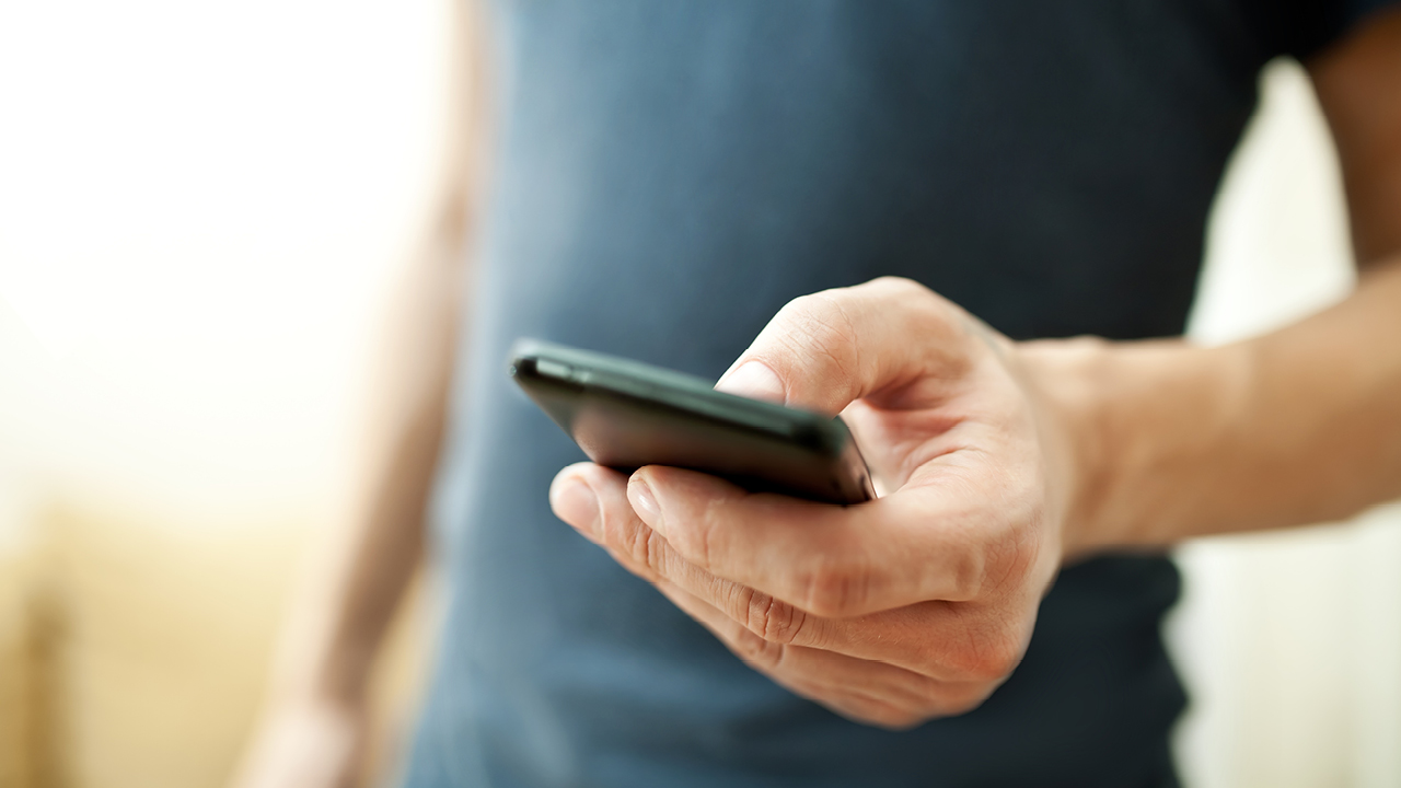 A person is typing on the mobile phone; image used for HSBC Australia report a lost and stolen card