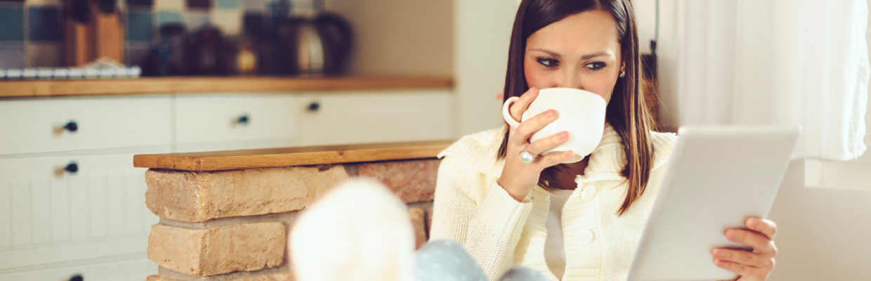 A woman drinking coffee and checking on iPad; image used for HSBC welcome to Start Smart.