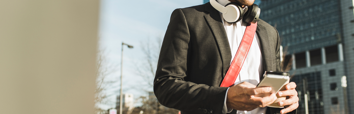 A man wearing headphones and holding phone; image used for HSBC Australia digital secure key.