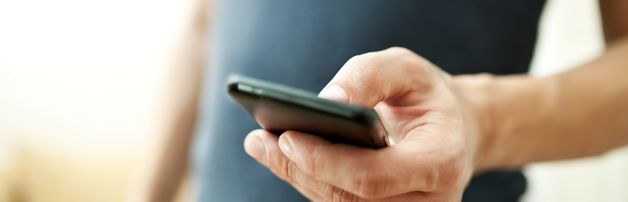 A man holding a smartphone on hand; image used for HSBC Safeguard. 