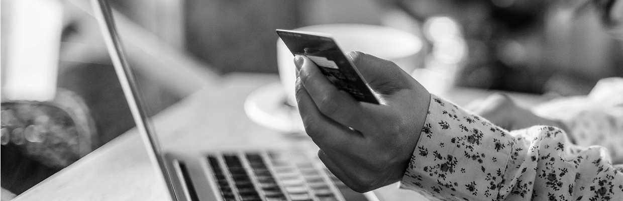 A person looking at a credit card while checking on laptop; image used for HSBC Australia activate your credit card.