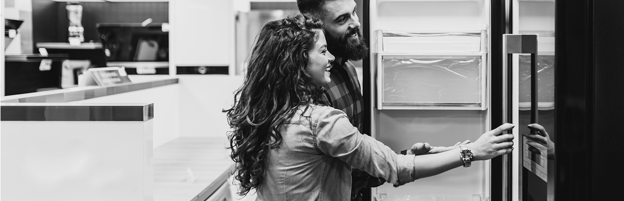 A couple opening the refrigerator at a home appliance store; image used for HSBC Australia become a HSBC interest free retailer.