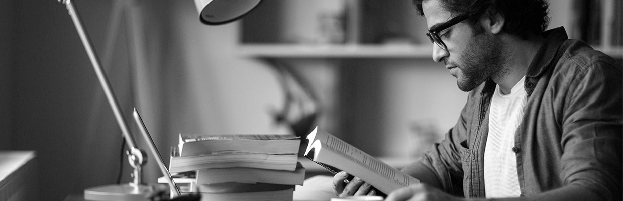 A man reading book on a desk; image used for HSBC Australia Education Loan.