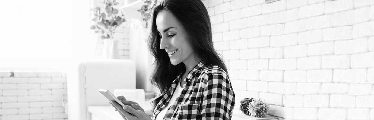 A woman checking mobile in a living room; image used for HSBC Australia getting on top of your finances.