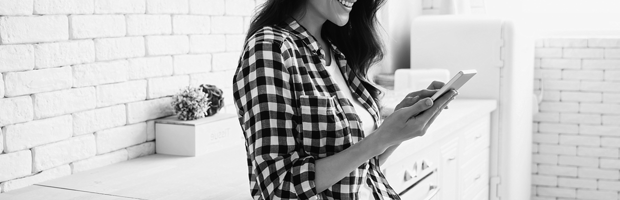 A woman checking on mobile with a smile at living room; image used for HSCB Australia Balance transfer.