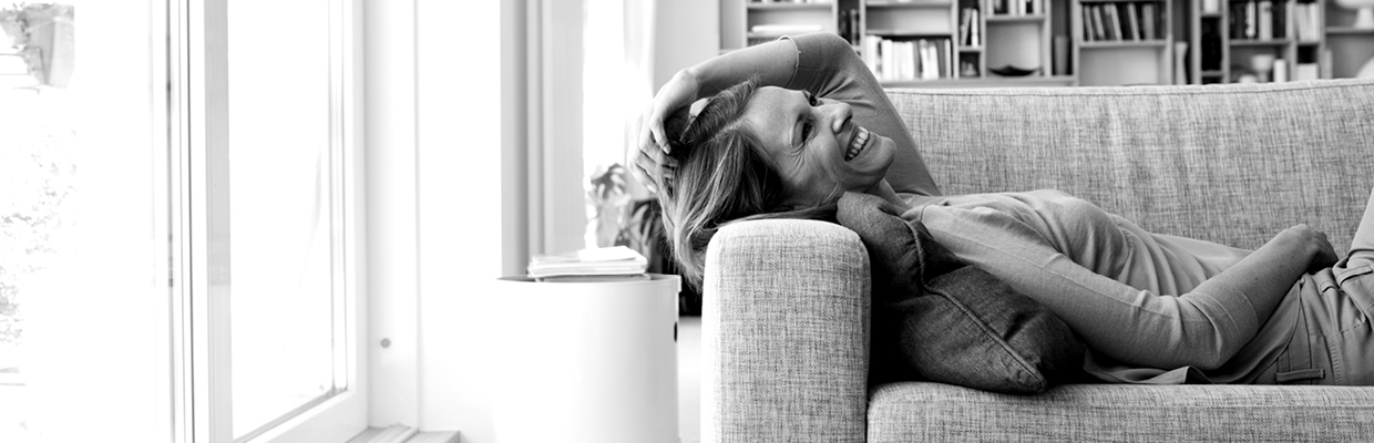 A smiling woman lying down on sofa; image used for HSBC Australia What is Balance transfer.