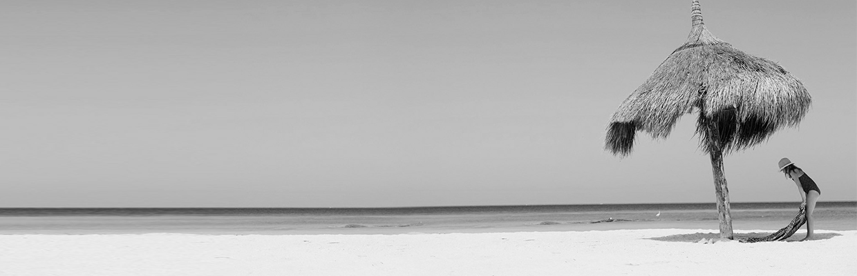 A woman putting a mat on beach side; image used for HSBC Australia holiday loan page.