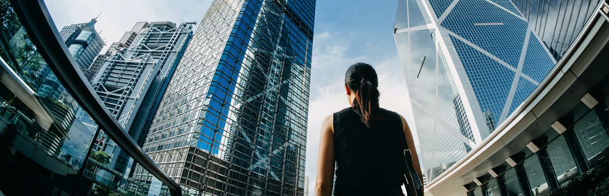 Woman standing between financial skyscrapers; image used for HSBC Australia Exchange Traded Funds (ETFs).