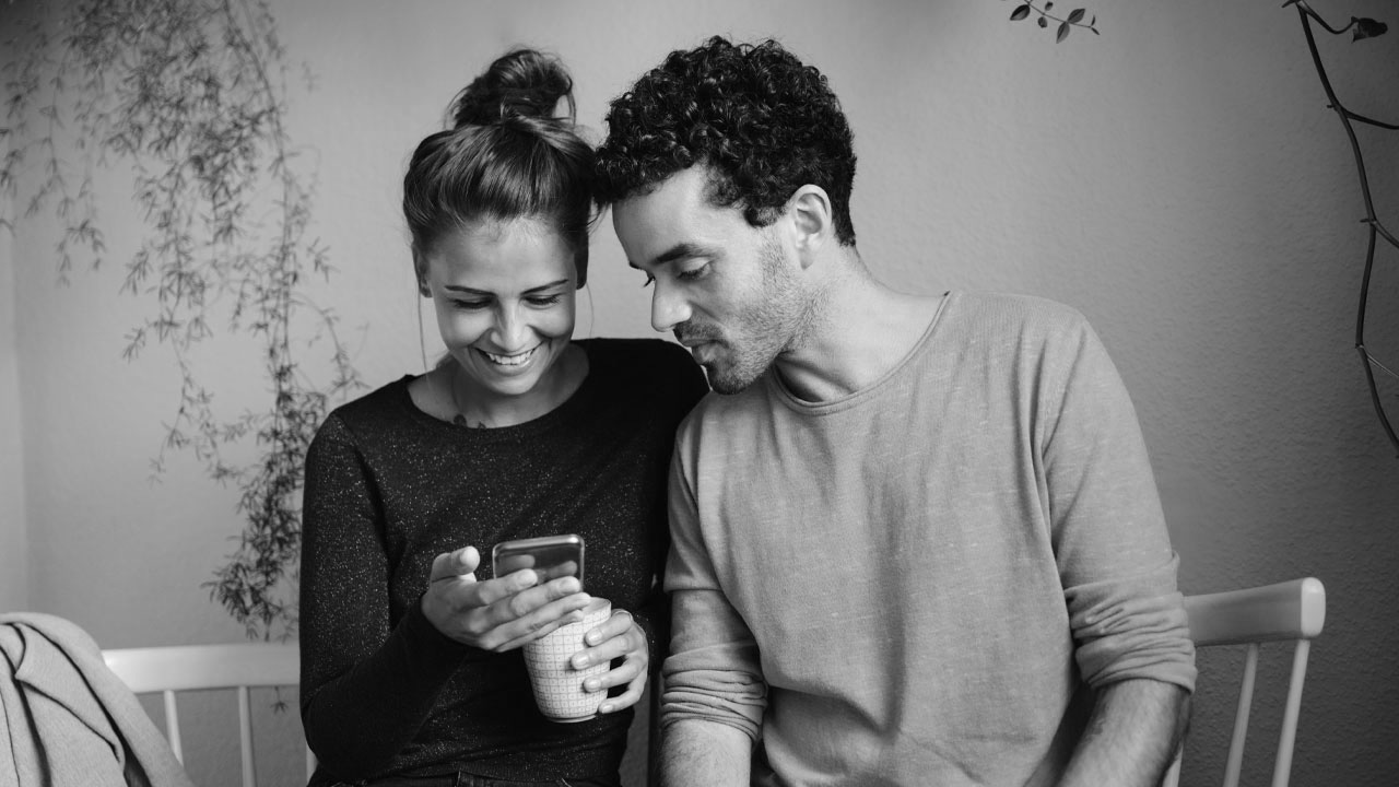 A pair of couple checking with the phone; image used for HSBC Australia How to open a joint bank account online.