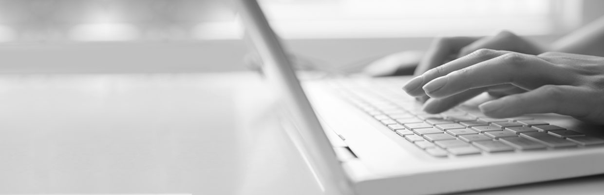 A woman typing on a laptop; image used for HSBC Common types of fraud and scams.