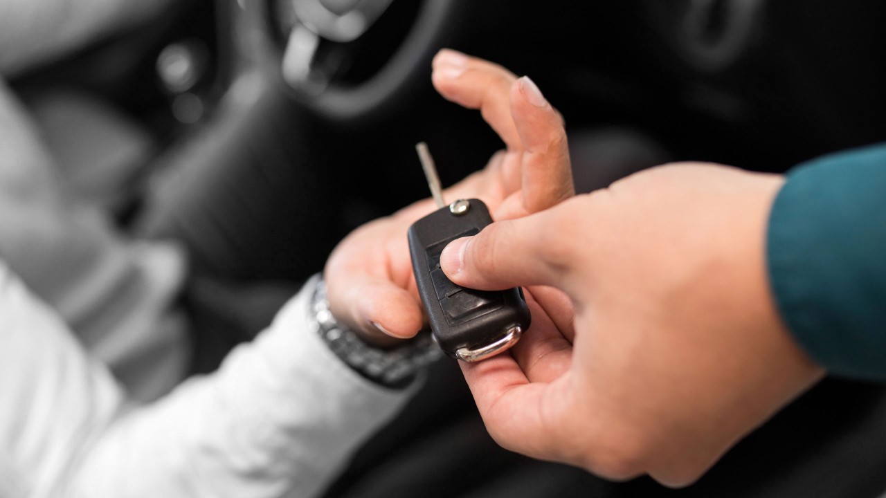 A man handing a car key to another man; image used for HSBC Australia How a car loan can help when buying a car.
