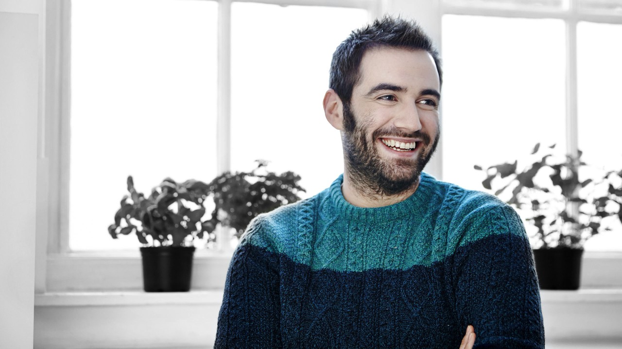 A man standing near a window with lots of plants; image used for HSBC Australia All you need to know about applying for a personal loan.